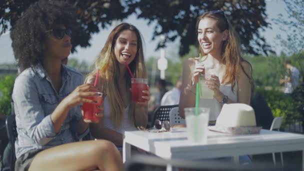 Stylish young girls having drinks outside